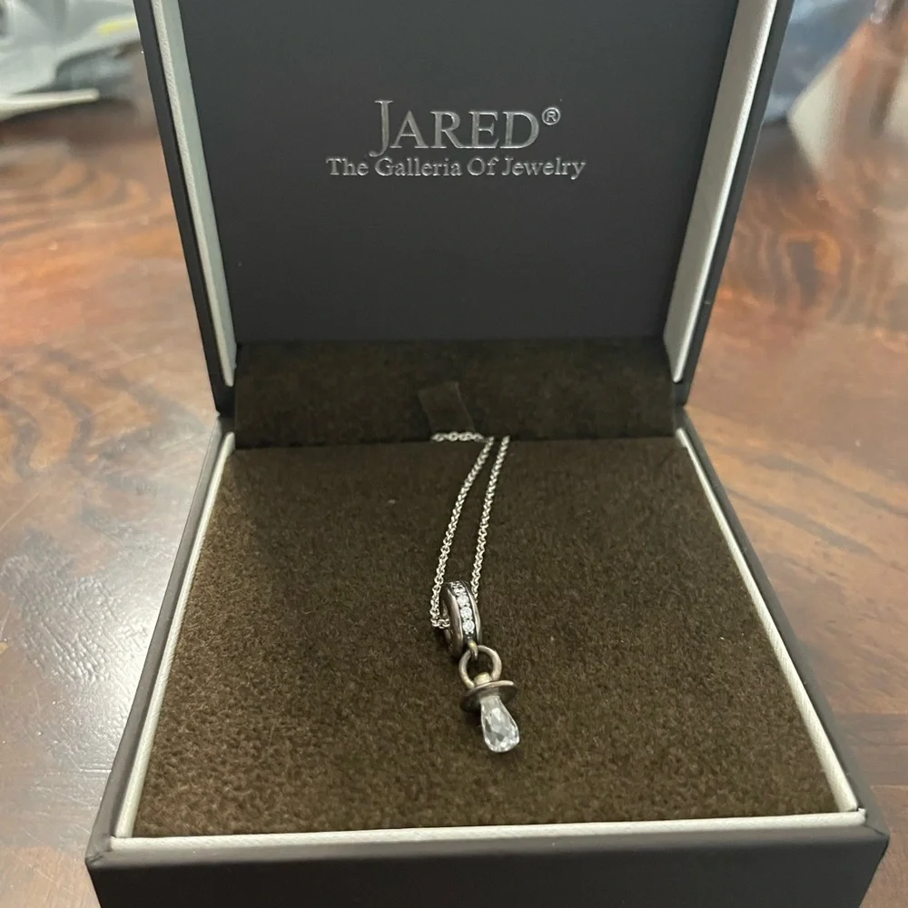 Silver necklace with a circle at end and pacifier at end of circle - Picture 3 of 6